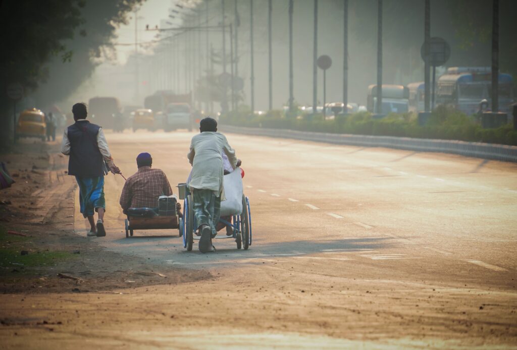 A man pulling a person on a cart